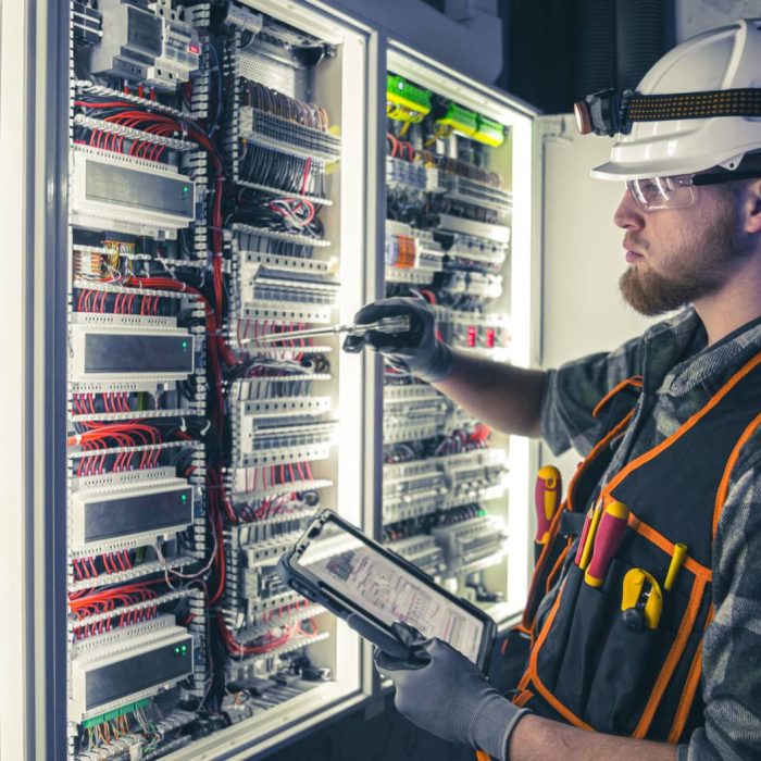 electrician-overalls-focused-work-switchboard-with-fuses-using-tablet-scaled
